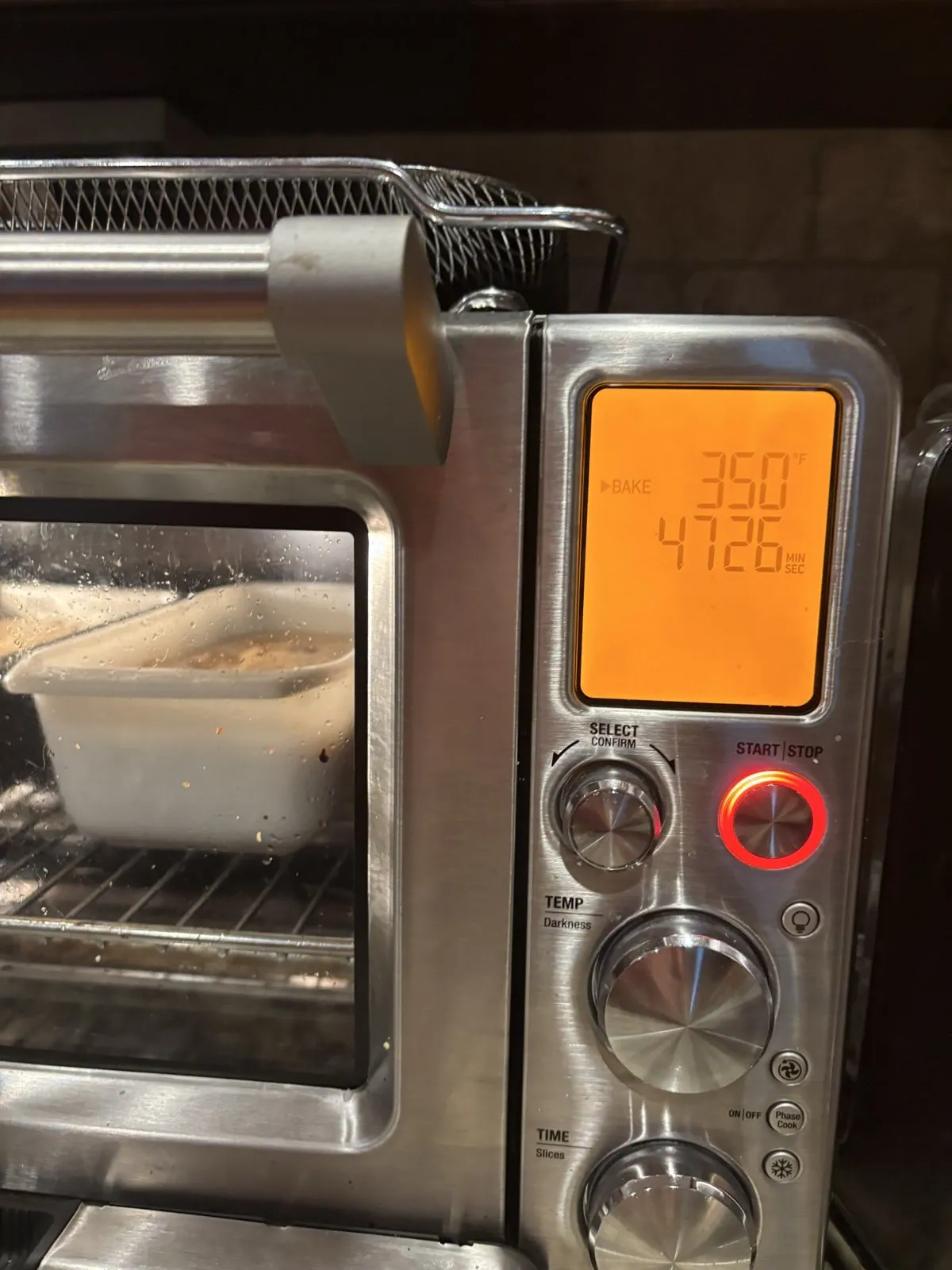 A countertop convection oven baking a dish at 350 degrees.